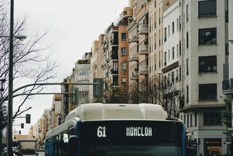 Trasera de un autobús urbano de Madrid con el letrero «61 Moncloa» en una calle con semáforos.